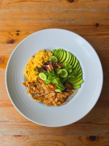 un plato blanco de comida en una mesa de madera en Kata Station Boutique Hotel, en Kata Beach