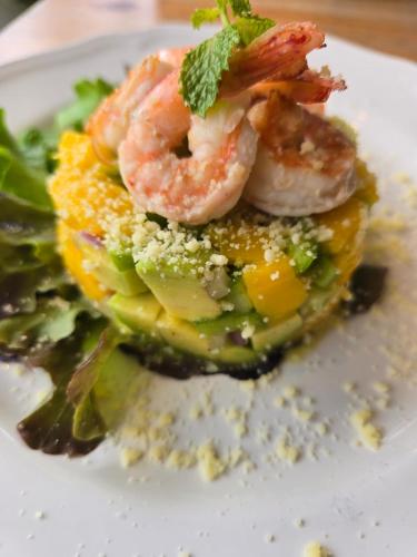 un plato de comida con camarones encima de las verduras en Kata Station Boutique Hotel, en Kata Beach