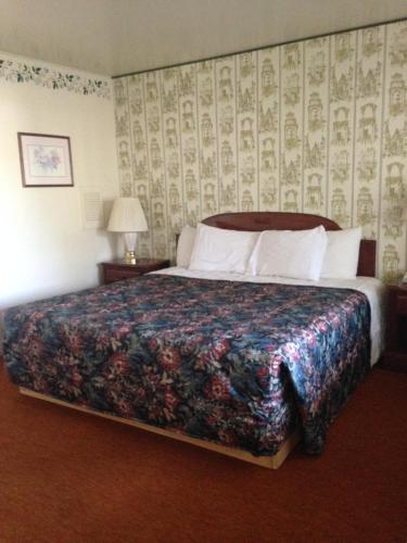 1 dormitorio con 1 cama grande con colcha de flores en Heidelberg Motel, en Bridgeport