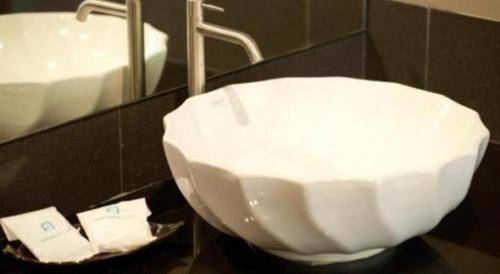 a bathroom with a white sink and a mirror at Amnauysuk Hotel in Ban Si Than