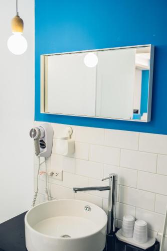 a bathroom with a white sink and a mirror at So Art Guesthouse 旅人藝棧民宿 in Sanyi