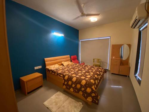 Un dormitorio con una cama y una pared azul. en yash villa, en Lonavala