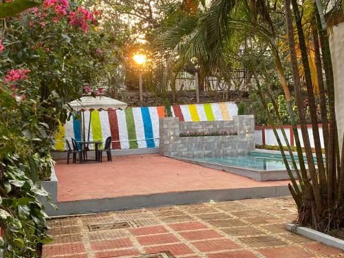 Un patio trasero con piscina, mesa y silla. en yash villa, en Lonavala