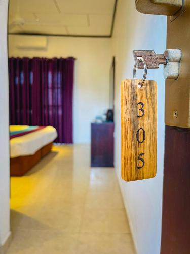 a tag on the door of a room with a bed at Seaport Negombo in Negombo