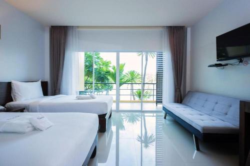 ein Hotelzimmer mit zwei Betten und einer Couch in der Unterkunft Tamali Hotel in Ban Yuan Lae