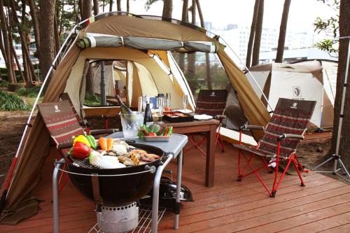 a tent with a grill and a table with food in it at Maison Glad Jeju in Jeju