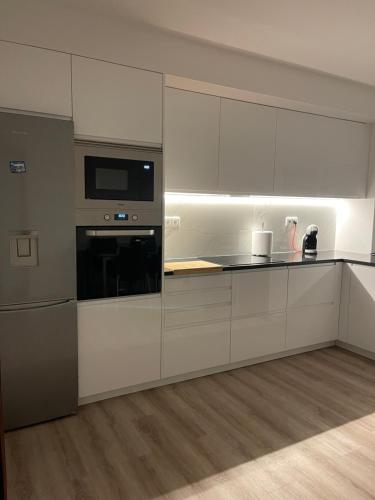 a kitchen with white cabinets and a stove top oven at Lar do Sossego in Geme