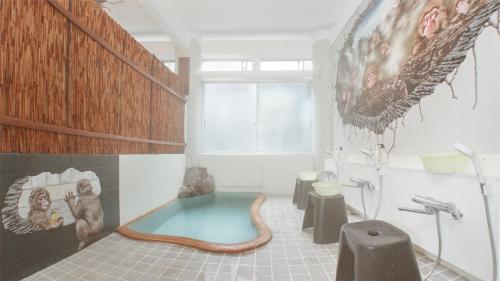 a bathroom with a tub in the middle of the room at Snow Monkey Lodge in Yamanouchi