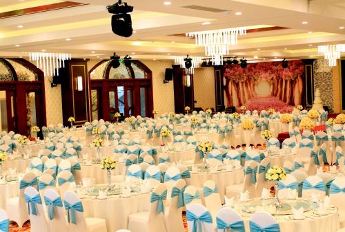 a large banquet hall with white tables and chairs at Hai Yen Luxury Hotel in Cẩm Phả