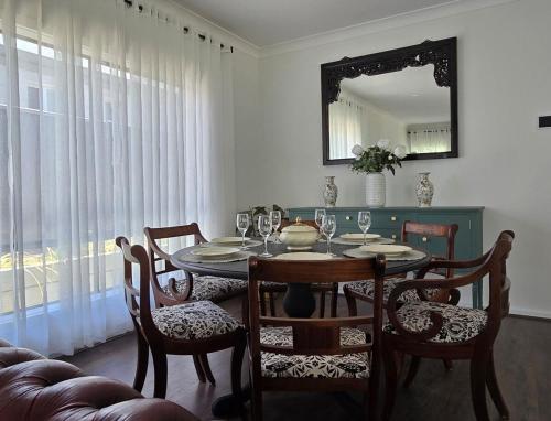 a dining room with a table and chairs and a mirror at Brand New Home with Pool in Lyndoch