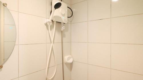 una doccia in bagno con telefono a parete di Hotel De Amado by RedDoorz a Dagupan