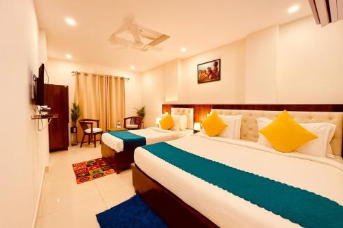 a hotel room with two beds with yellow and blue at Sitara Economy The Pacific, Haridwar in Haridwār