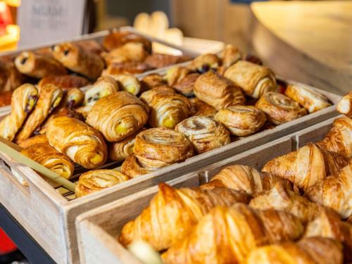un mucchio di croissant e altri prodotti da forno esposti di ibis Toulouse Pont Jumeaux a Tolosa