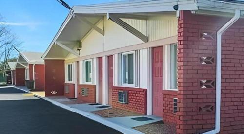 a brick building with a red door in a parking lot at Travelodge by Wyndham Bay Shore Long Island in Bay Shore