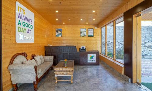 a living room with a couch and a table at Treebo M R Villa in Manāli