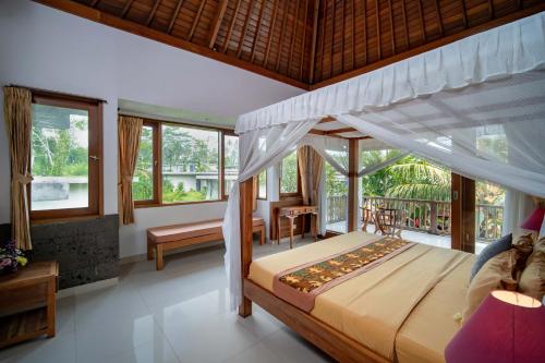 ein Schlafzimmer mit einem Himmelbett in der Unterkunft Villa Mahayoni in Bedahulu