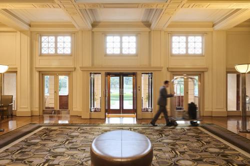 Ein Mann geht durch die Lobby eines Gebäudes. in der Unterkunft Hyatt Hotel Canberra - A Park Hyatt Hotel in Canberra