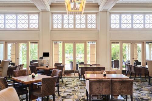 a restaurant with tables and chairs and windows at Hyatt Hotel Canberra - A Park Hyatt Hotel in Canberra