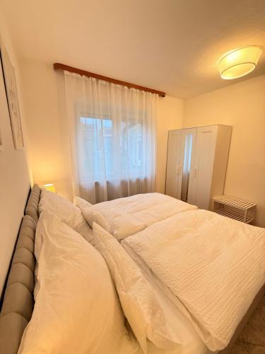 a large bed in a bedroom with a window at Gemütliche 2 Zimmer Wohnung Bad Steben in Bad Steben