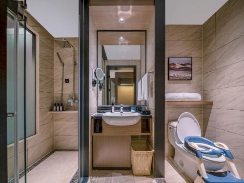 un baño con inodoro y lavabo en Royalton Hotel Xi'an Qujiang Conference Center Mixc, en Xi'an