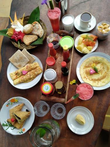 a wooden table with plates of food on it at Sumatra Orangutan Discovery Villa in Bukit Lawang