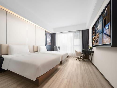 Una habitación de hotel con dos camas y un televisor. en Royalton Hotel Xi'an Qujiang Conference Center Mixc, en Xi'an