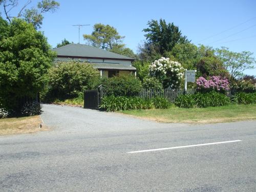 a house on the side of a road with flowers at Villa in the Vines in Martinborough 