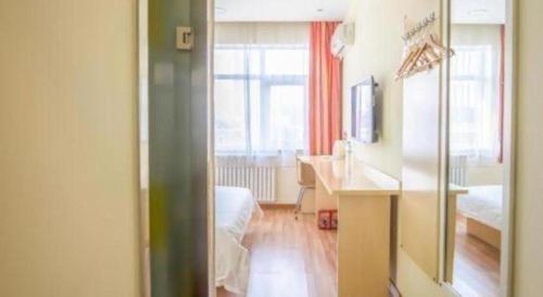 ein Zimmer mit einem Schlafzimmer mit Schreibtisch und Fenster in der Unterkunft 7Days Inn Tianjin Fifth Avenue Youyi Road Branch in Tianjin