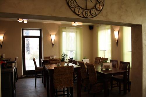 a dining room with a large clock on the wall at Hotel - Bistro - 3-Eck in Merchweiler