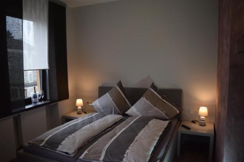 ein Schlafzimmer mit einem Bett mit Kissen und einem Fenster in der Unterkunft Hotel - Bistro - 3-Eck in Merchweiler