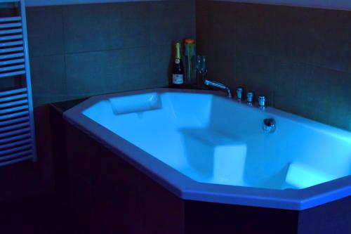 a bath tub with a blue light in a bathroom at Hotel - Bistro - 3-Eck in Merchweiler