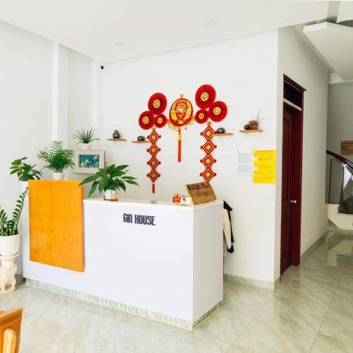 a reception counter in a room with flowers on the wall at Gin House Đà Lạt in Da Lat
