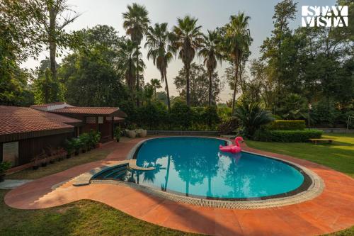 a swimming pool in the backyard of a house at StayVista at The Birdwood Estate with Gym and Pool in New Delhi