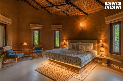 a bedroom with a bed and a table and chairs at StayVista at The Birdwood Estate with Gym and Pool in New Delhi