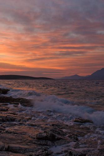 a sunset over a body of water with rocks at Villa Sofia in Povlja