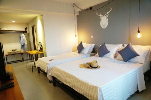 a hotel room with two beds with a hat on top at Hansa Bangkok House in Bangkok