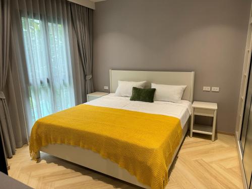 una camera da letto con un grande letto con una coperta gialla di Апартаменты у океана пляж Бангтао Title Legendary Bangtao a Bang Tao Beach