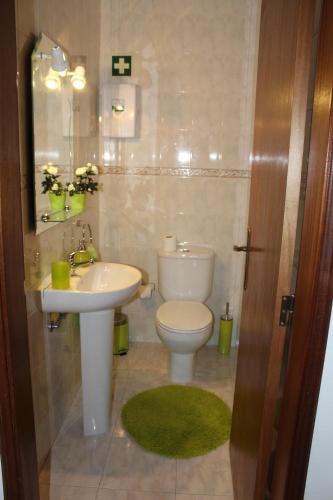 a bathroom with a white toilet and a sink at Villa Figueira in Portimão