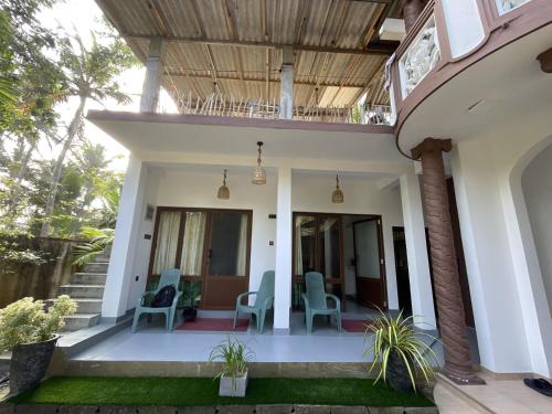 a house with blue chairs on the porch at Praba villa in Midigama East