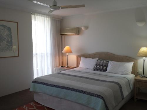 un dormitorio con una cama y una ventana en Kirribilli Apartments, en Brisbane