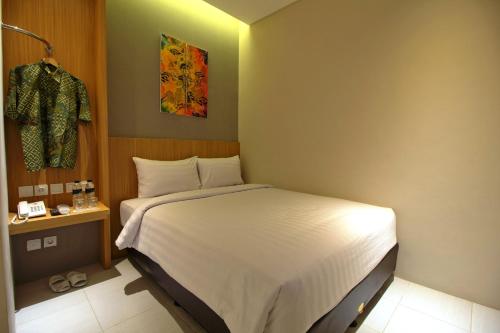 a bedroom with a white bed in a room at Vinotel Cirebon in Cirebon