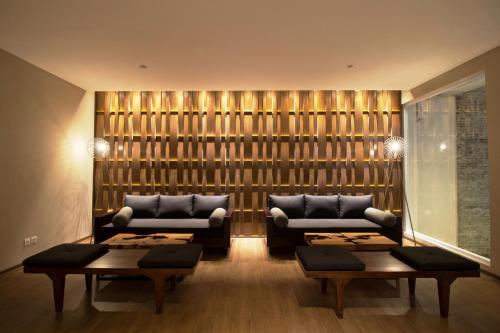 a living room with two couches and two tables at Vinotel Cirebon in Cirebon