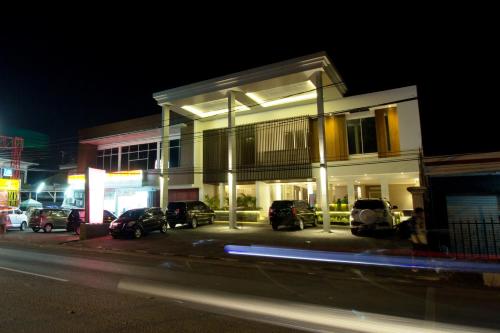 a building with cars parked in a parking lot at night at Vinotel Cirebon in Cirebon