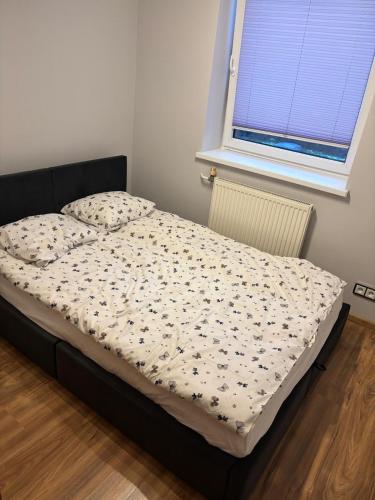 ein Bett in einem Schlafzimmer mit einem Fenster in der Unterkunft Apartament na Południu in Zduńska Wola