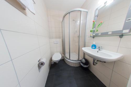 a bathroom with a sink and a shower and a toilet at Hollis Rast in Sangerhausen