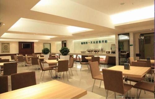 a dining room with tables and chairs in a restaurant at City Comfort Inn Shenzhen Longhua Bus Station Qinghu Metro Station in Tiantangwei