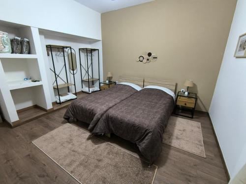 Aegina Downtown Apartments 1 في ايجينا تاون: غرفة نوم بها سرير كبير وطاولتين