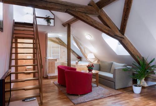 a living room with a staircase and red chairs at Penzion Baltazar Mikulov in Mikulov
