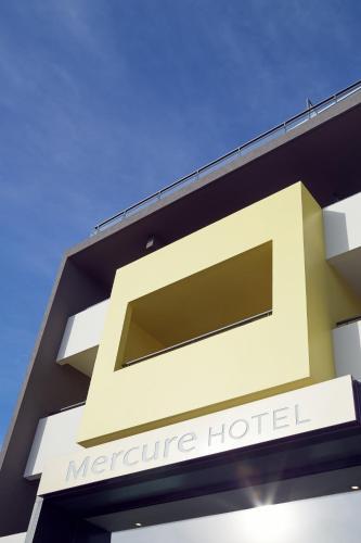 a sign for a metro centre hotel on a building at Mercure Hotel Golf Cap d'Agde in Cap d'Agde