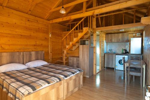 Sunrise Gelati في Motsameta: غرفة نوم مع سرير في كوخ خشبي